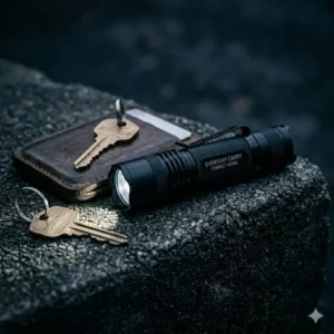 A slim EDC hand light with a pocket clip resting next to a wallet and keys.